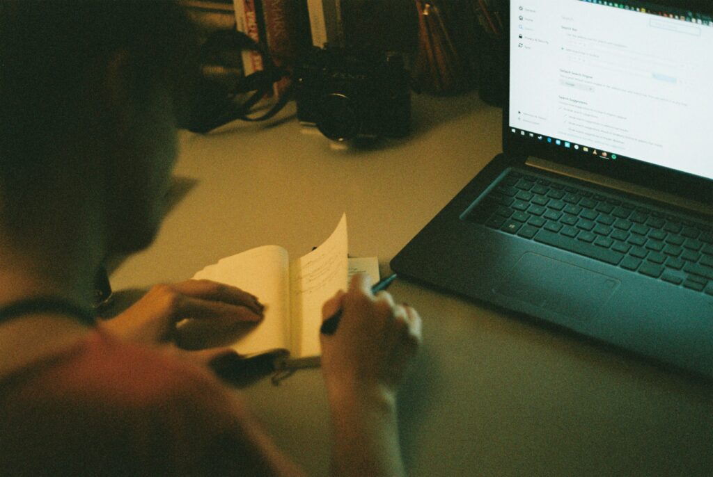 “How to Write a Freelance Case Study That Wins Clients – freelancer writing notes on laptop at workspace.”